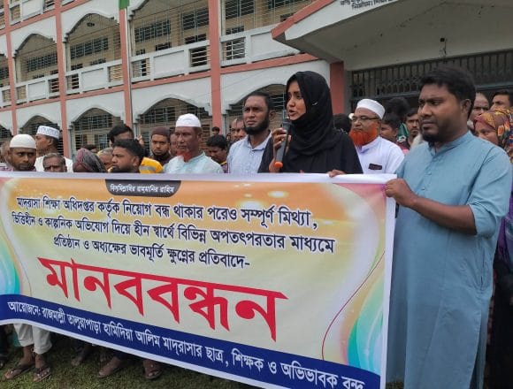 রাজারহাটে ষড়যন্ত্র ও মিথ্যা অপপ্রচারের প্রতিবাদে রাজমাল্লী তালুয়াপাড়া হামিদিয়া মাদরাসায় পাল্টা মানববন্ধন-